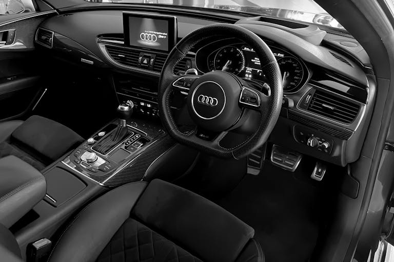 Explore the elegant black and white detailing in a luxury car's interior, featuring a modern dashboard and steering wheel.