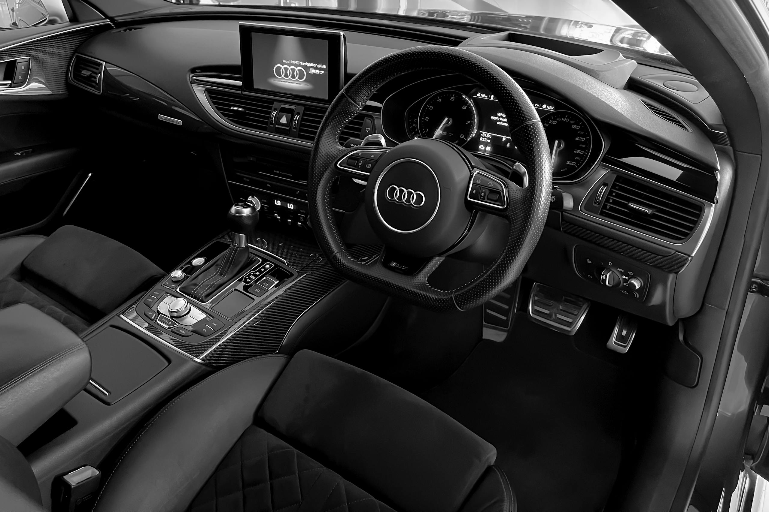 Explore the elegant black and white detailing in a luxury car's interior, featuring a modern dashboard and steering wheel.